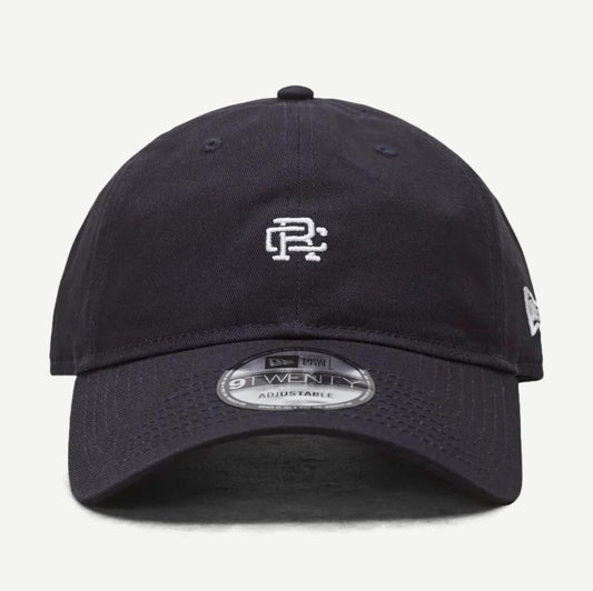 Reigning Champ New Era 9Twenty Mini Monogram Navy cap, adjustable hat with embroidered logo, front view.