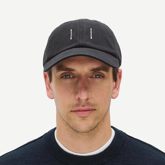 Reigning Champ cotton chino low pro strapback cap in washed black, front view showing adjustable strap and curved brim.