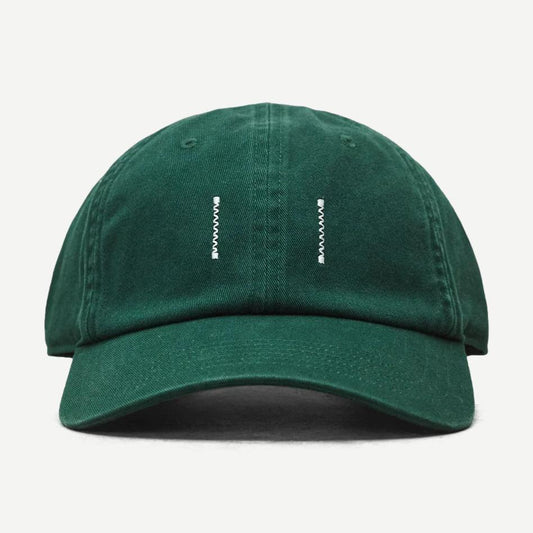 Reigning Champ cotton chino low pro strapback cap in washed British racing green, showing front view and adjustable strap.