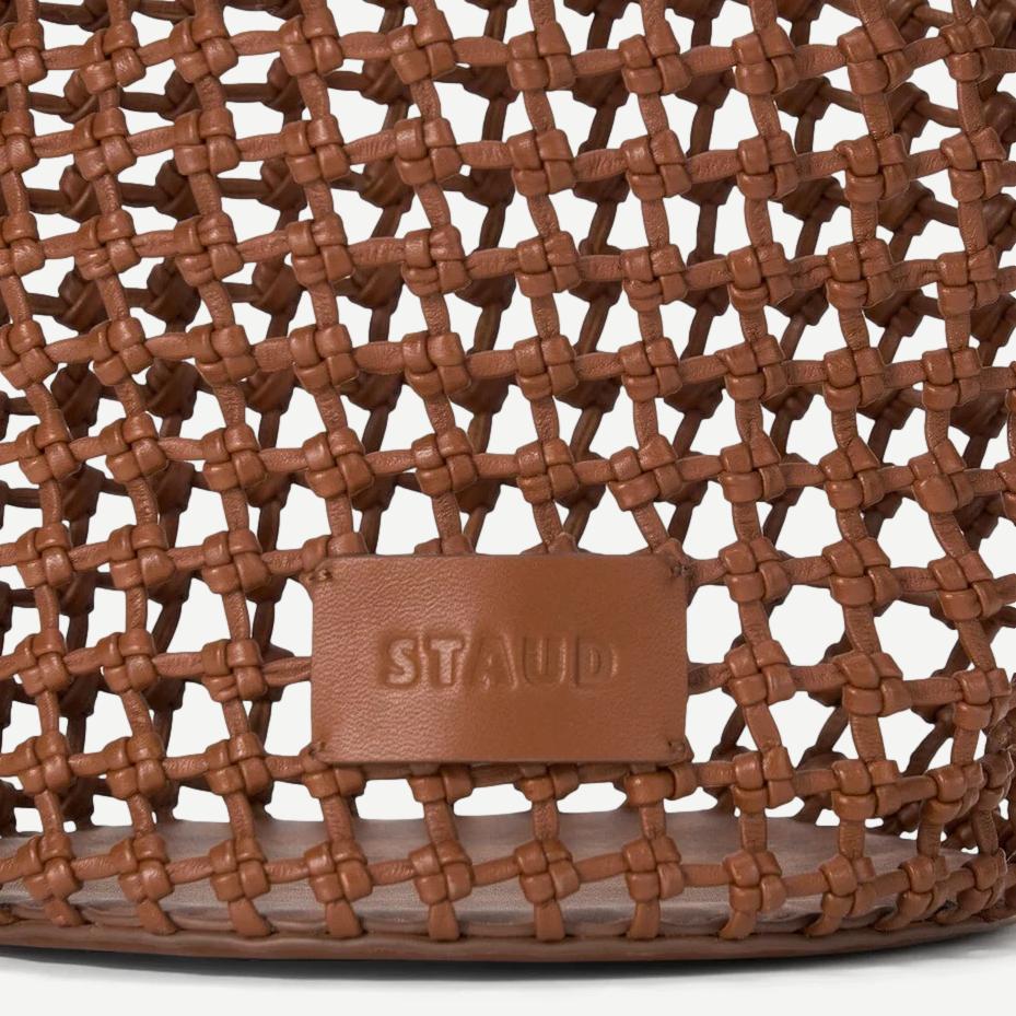 Tan Staud Caro Bucket Bag made of purses material, featuring a rounded shape, stylish handle, and minimalist design.