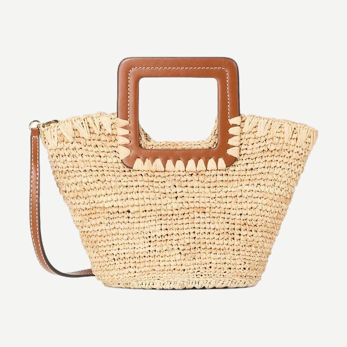 Staud Shirley Raffia Mini Bucket Purse in natural tan with woven raffia texture and short handle, stylish and compact accessory.