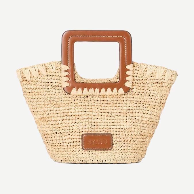 Staud Shirley Raffia Mini Bucket Bag in natural and tan with woven raffia texture and short shoulder strap.