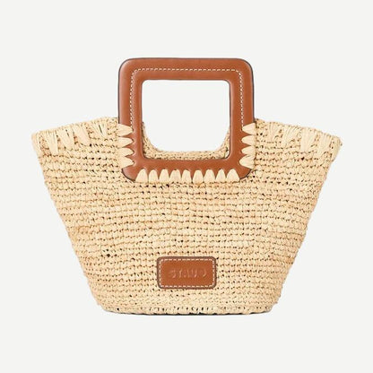 Staud Shirley Raffia Mini Bucket Bag in natural and tan with woven raffia texture and short shoulder strap.