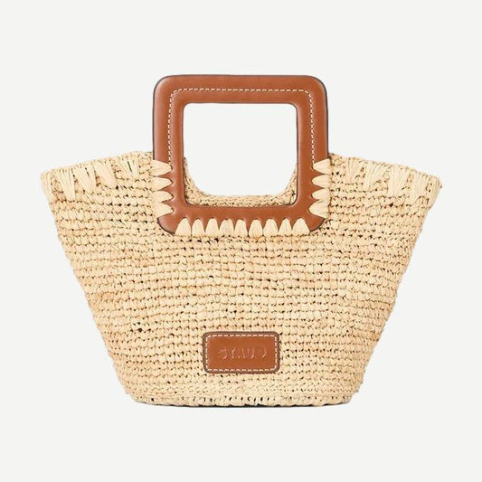 Staud Shirley Raffia Mini Bucket Bag in natural and tan with woven raffia texture and short shoulder strap.