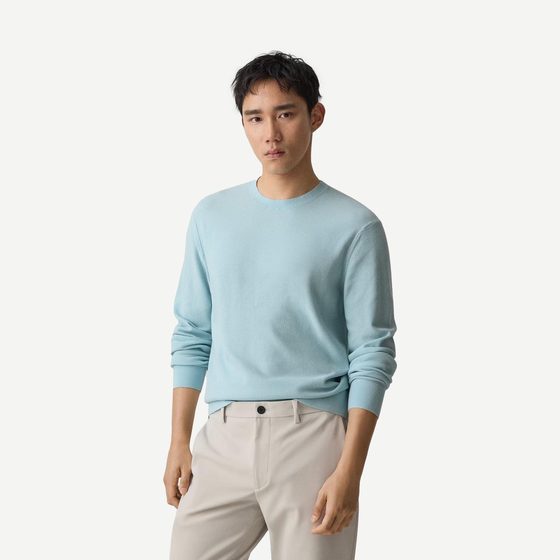 Light ocean air-colored Theory Riland crewneck sweater displayed on a hanger, showcasing its soft knit fabric and relaxed fit.