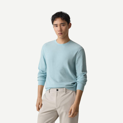 Light ocean air-colored Theory Riland crewneck sweater displayed on a hanger, showcasing its soft knit fabric and relaxed fit.