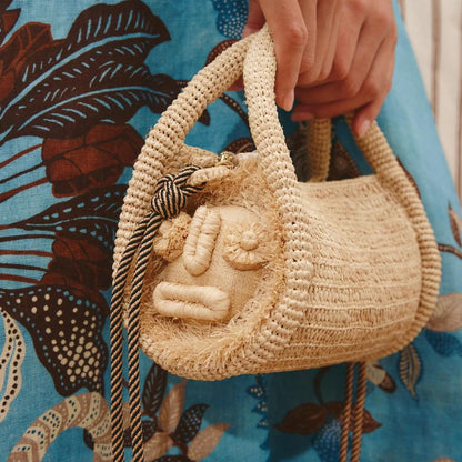 Alémais Sunlit Raffia Mini Barrel Bag in blonde with woven raffia texture, small purse with leather accents and top handle.