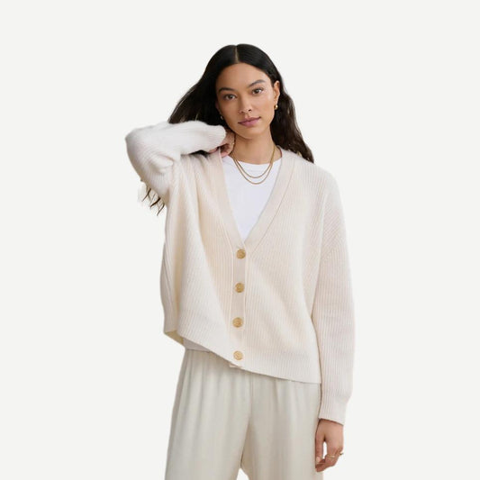 Jenni Kayne ivory cropped cashmere cocoon cardigan displayed on a hanger showing its soft, cozy texture and relaxed fit.