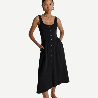 Jet black Nation LTD Laurel Midi Dress displayed on a hanger with flowing fabric and a fitted silhouette.