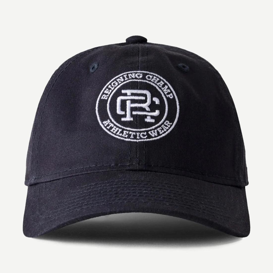 Reigning Champ Navy and White New Era Woven 9Twenty Crest Logo Cap, adjustable hat with embroidered crest and classic design.