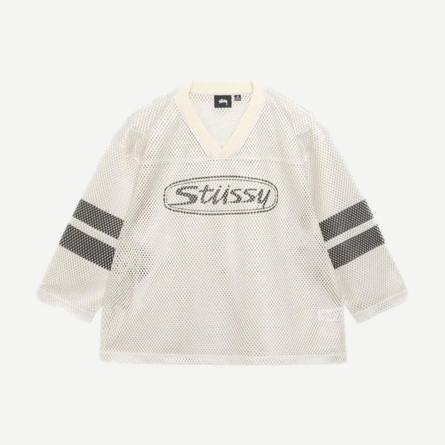 Stussy Trucker Team Jersey in tan, casual shirt with a relaxed fit and classic trucker style, displayed on a hanger.