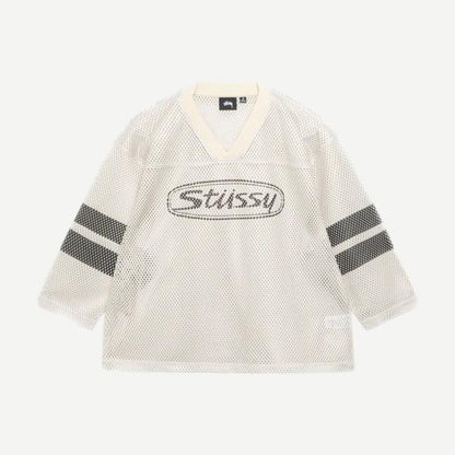 Stussy Trucker Team Jersey in tan, casual shirt with a relaxed fit and classic trucker style, displayed on a hanger.